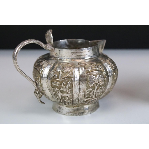 622 - Indian Lucknow white metal silver jug of gourd form with panelled sides featuring animals, flowers a... 