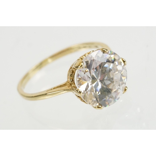 258 - Cubic zirconia and gold solitaire ring being set with a large round brilliant cut white stone in a h... 