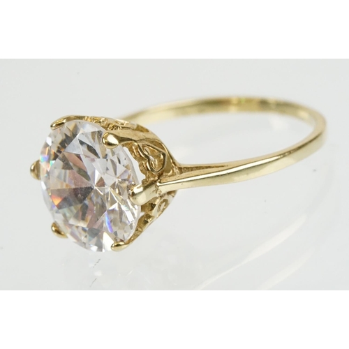 258 - Cubic zirconia and gold solitaire ring being set with a large round brilliant cut white stone in a h... 