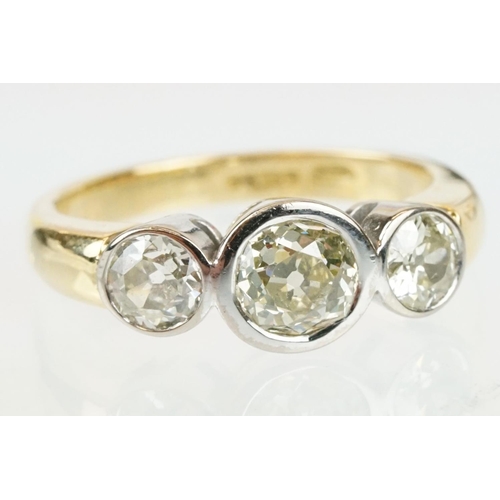 283 - 18ct gold and diamond three stone ring. The ring having three round old cut diamonds in bezel settin... 