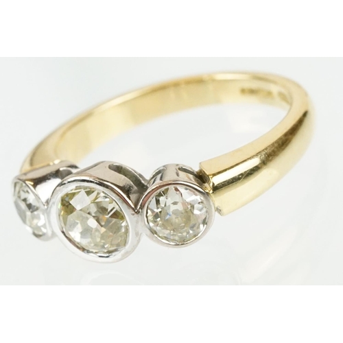 283 - 18ct gold and diamond three stone ring. The ring having three round old cut diamonds in bezel settin... 