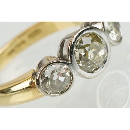 283 - 18ct gold and diamond three stone ring. The ring having three round old cut diamonds in bezel settin... 