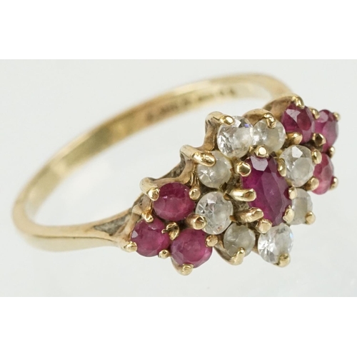 59 - Hallmarked 9ct gold ruby and white stone cluster ring. The ring being set with an oval cut ruby to c... 