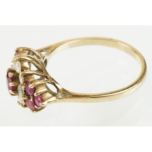 59 - Hallmarked 9ct gold ruby and white stone cluster ring. The ring being set with an oval cut ruby to c... 