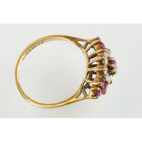 59 - Hallmarked 9ct gold ruby and white stone cluster ring. The ring being set with an oval cut ruby to c... 