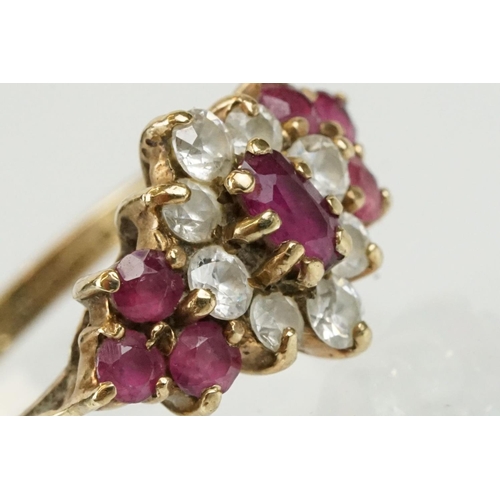 59 - Hallmarked 9ct gold ruby and white stone cluster ring. The ring being set with an oval cut ruby to c... 