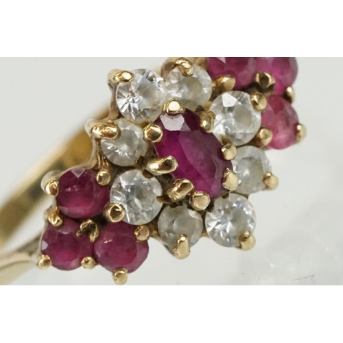 59 - Hallmarked 9ct gold ruby and white stone cluster ring. The ring being set with an oval cut ruby to c... 