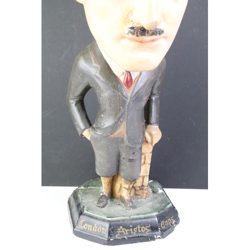 134 - London Aristos Caps Art Deco chalkware shop display figurine in the form of a gentleman leaning on a... 