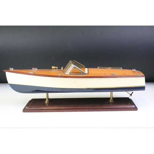 148 - Painted wooden model of a speedboat, raised on a rectangular base, approx 48cm long