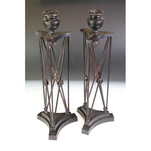 161 - Pair of cast metal candlesticks of architectural form with acorn details, raised on triform bases, m... 