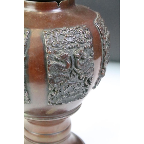 166 - Oriental bronze urn with cast relief decoration depicting mythical birds / creatures, approx 23cm hi... 