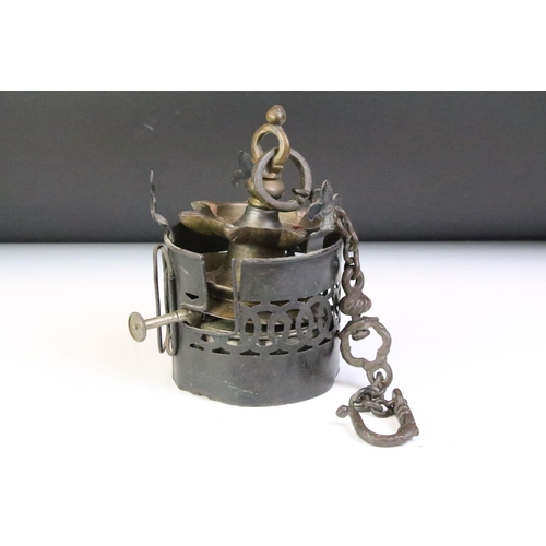 168 - Two antique metal oil burners to include a hanging brass Indian example and a cylindrical pierced me... 