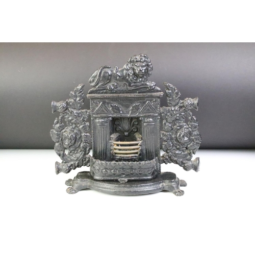 173 - Cast iron miniature fireplace with fire guard, surmounted by a lion, raised on four feet, measures a... 