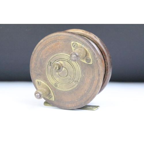 179 - A collection of three vintage fly fishing reels to include two wooden examples with brass fittings.