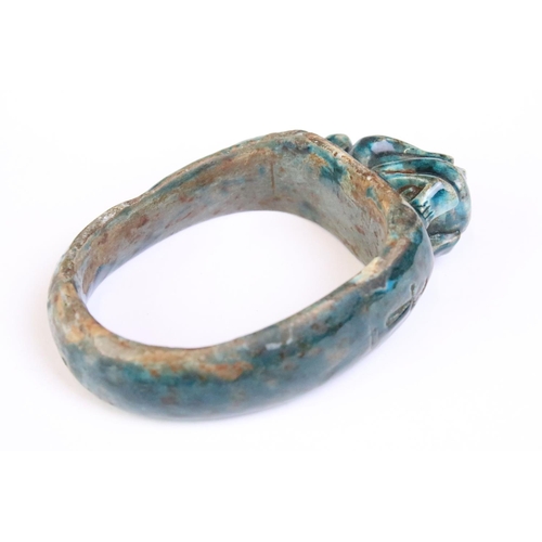 182 - An Egyptian faience bangle with green glaze and Ankh / key of life decoration to sides.