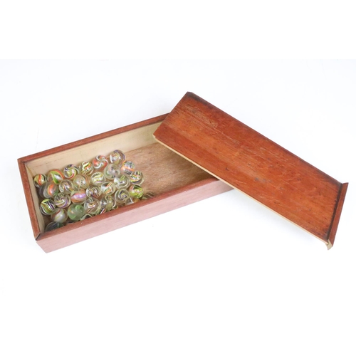 191 - An antique carved wooden solitaire board complete with antique marbles.