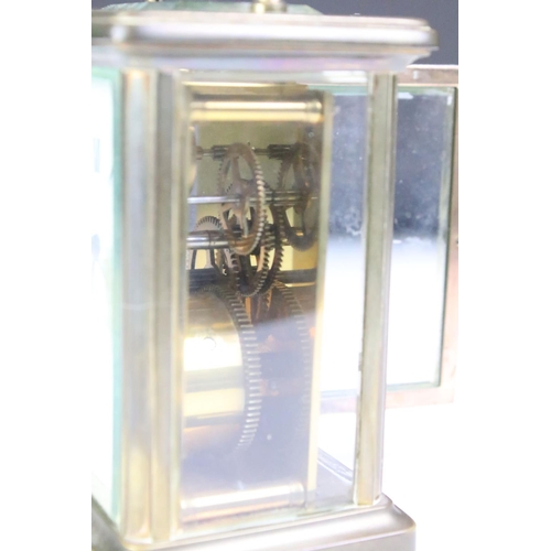 194 - A brass cased carriage clock with beveled glass panels, white enamel dial marked Tyer' Ltd, Ealing, ... 