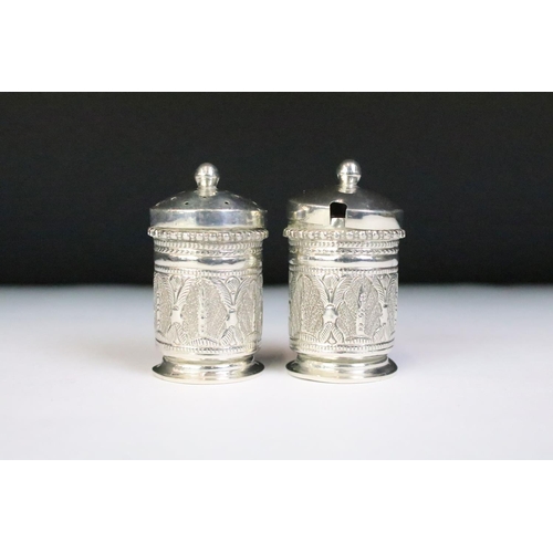 201 - A white metal three piece cruet set with matching tray, complete with salt spoon.