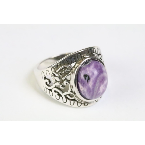 212 - A 925 sterling silver ladies ring with purple cabochon central stone with decorative shoulder work, ... 