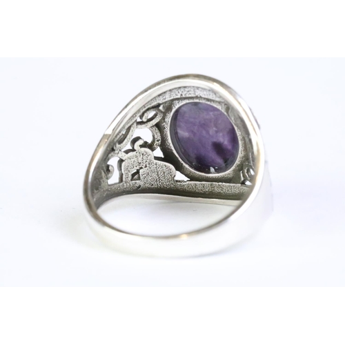 212 - A 925 sterling silver ladies ring with purple cabochon central stone with decorative shoulder work, ... 