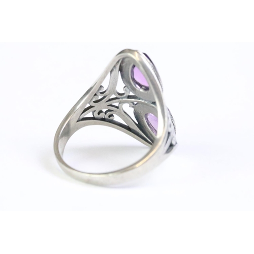 214 - A 925 sterling silver ladies ring set with double teardrop amethyst and decorative scroll work to sh... 