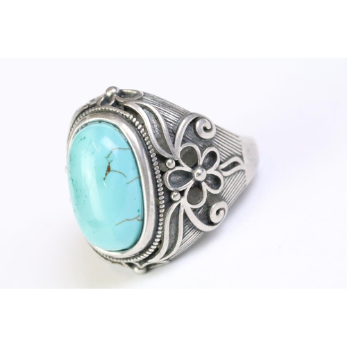 217 - A 925 Sterling silver with turquoise cabochon to centre ladies ring with decorative floral shoulders... 