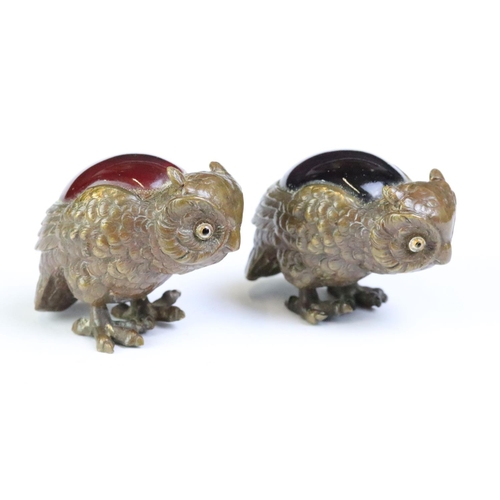 261 - A set of four bronze owl figures set with coloured glass backs.