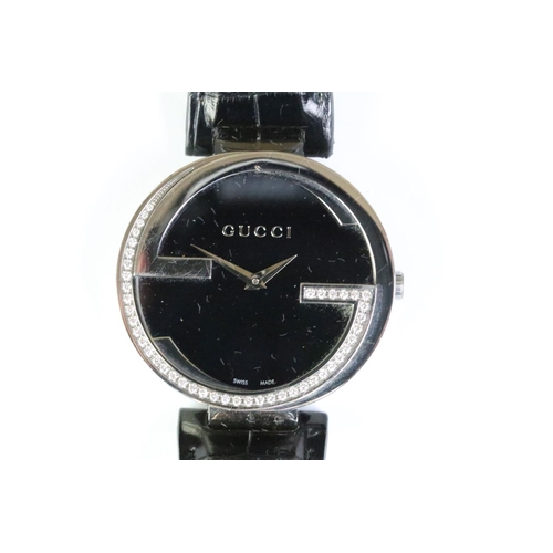 271 - Ladies Gucci diamond bezel wristwatch on black leather strap, complete with display box.