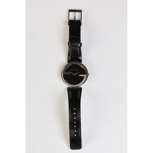 271 - Ladies Gucci diamond bezel wristwatch on black leather strap, complete with display box.