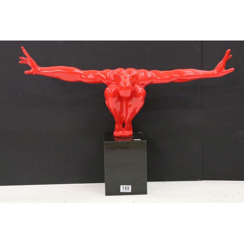 155 - Cast resin shop display figure in the form of a red crouching man mounted to a black marble block pl... 