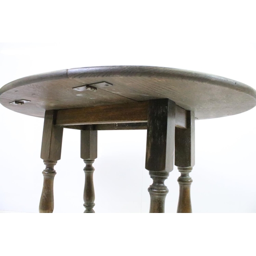 565 - 20th century oak drop leaf occasional coffee table on turned supports, 47cm high x 69cm wide x 57cm ... 