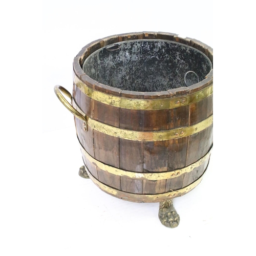 584A - Coopered barrel log basket / coal bucket with brass banding and twin brass handles on brass lion paw... 