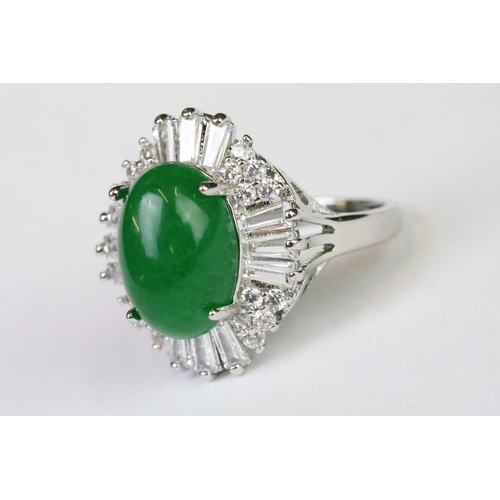 216A - A 925 sterling silver ladies dress ring of classical style with oval green centre stone with clear s... 