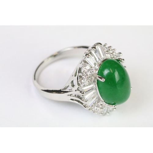 216A - A 925 sterling silver ladies dress ring of classical style with oval green centre stone with clear s... 