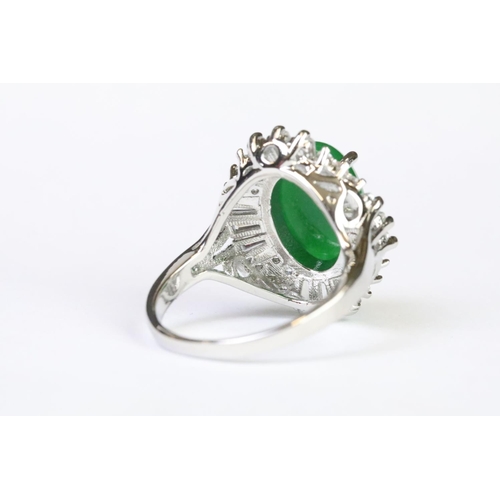 216A - A 925 sterling silver ladies dress ring of classical style with oval green centre stone with clear s... 