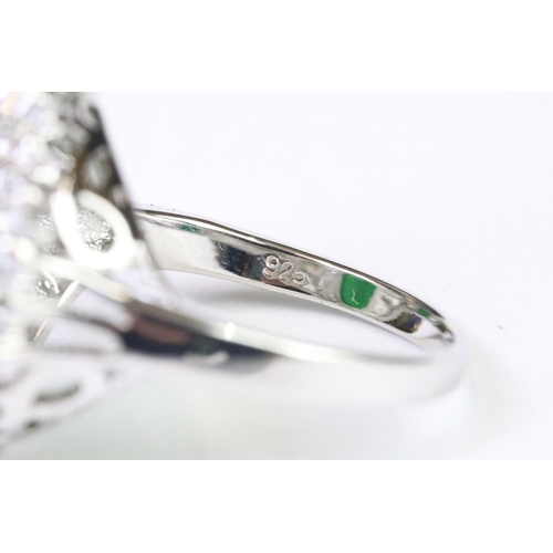 216A - A 925 sterling silver ladies dress ring of classical style with oval green centre stone with clear s... 