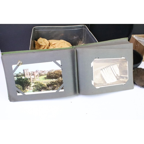 292 - A box of mixed collectables to include a vintage postcard album, wild boar tusks, fossils and rocks,... 