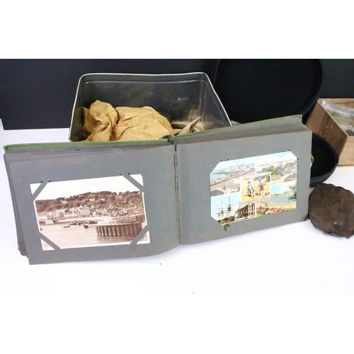 292 - A box of mixed collectables to include a vintage postcard album, wild boar tusks, fossils and rocks,... 