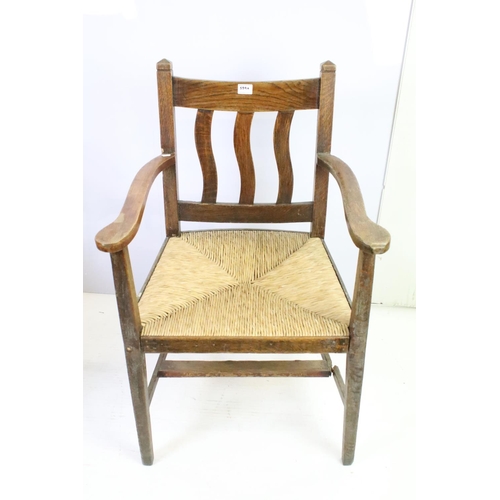 559A - Pair of oak elbow chairs, one with rush seat and another with a corduroy seat, 96cm high x 60cm wide... 