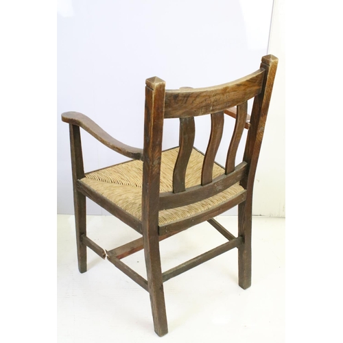 559A - Pair of oak elbow chairs, one with rush seat and another with a corduroy seat, 96cm high x 60cm wide... 