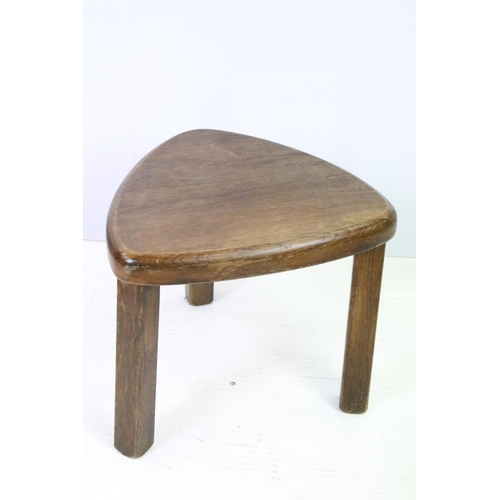 582 - 20th century nest of three oak tables of soft triangle form, the largest 38cm high x 51cm wide x 44c... 