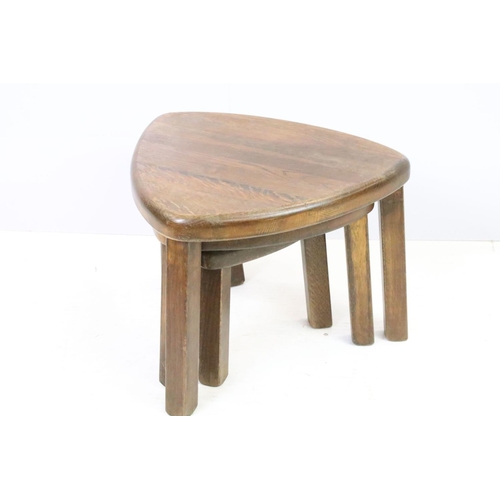 582 - 20th century nest of three oak tables of soft triangle form, the largest 38cm high x 51cm wide x 44c... 