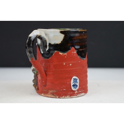 57 - Japanese Sumida Gawa pottery mug / tankard, with relief decoration of a figure, signed Ryosai, appro... 