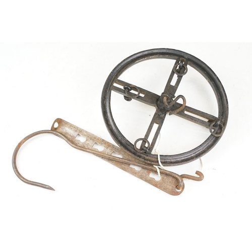 375 - A vintage brass preserve pan together with a clockwork and cast iron meat hanger.