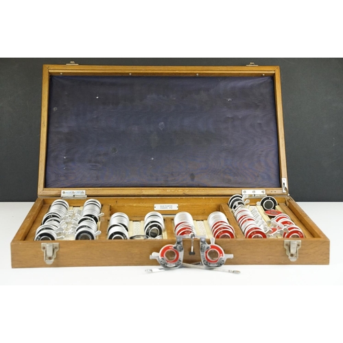 381 - A vintage British made opticians eye testing set of lenses with spectacles.