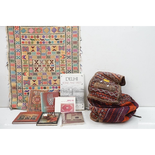 385 - A large carpet bag together with a selection of books to include Indian tribal and amulets.