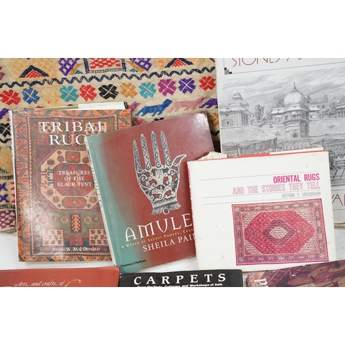 385 - A large carpet bag together with a selection of books to include Indian tribal and amulets.