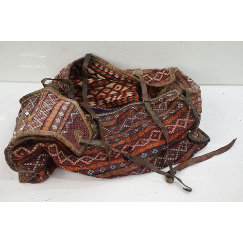 385 - A large carpet bag together with a selection of books to include Indian tribal and amulets.