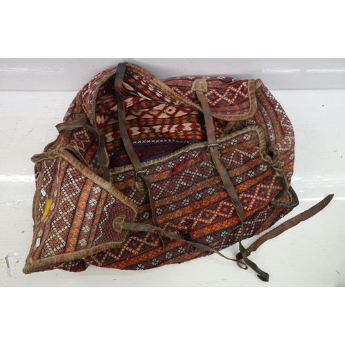 385 - A large carpet bag together with a selection of books to include Indian tribal and amulets.