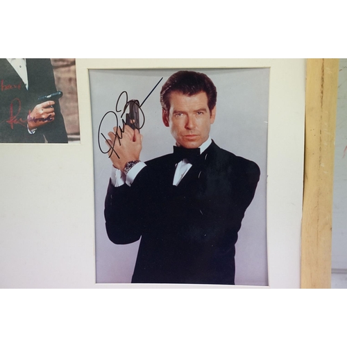 399 - Set of five James Bond photographs, signed, 56 x 60cm overall, James Bond 007 poster, gun symbol log... 